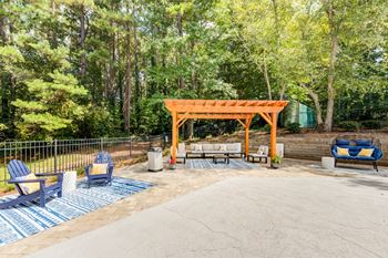 Outdoor lounge with grilling stations, table seating, and corn hole